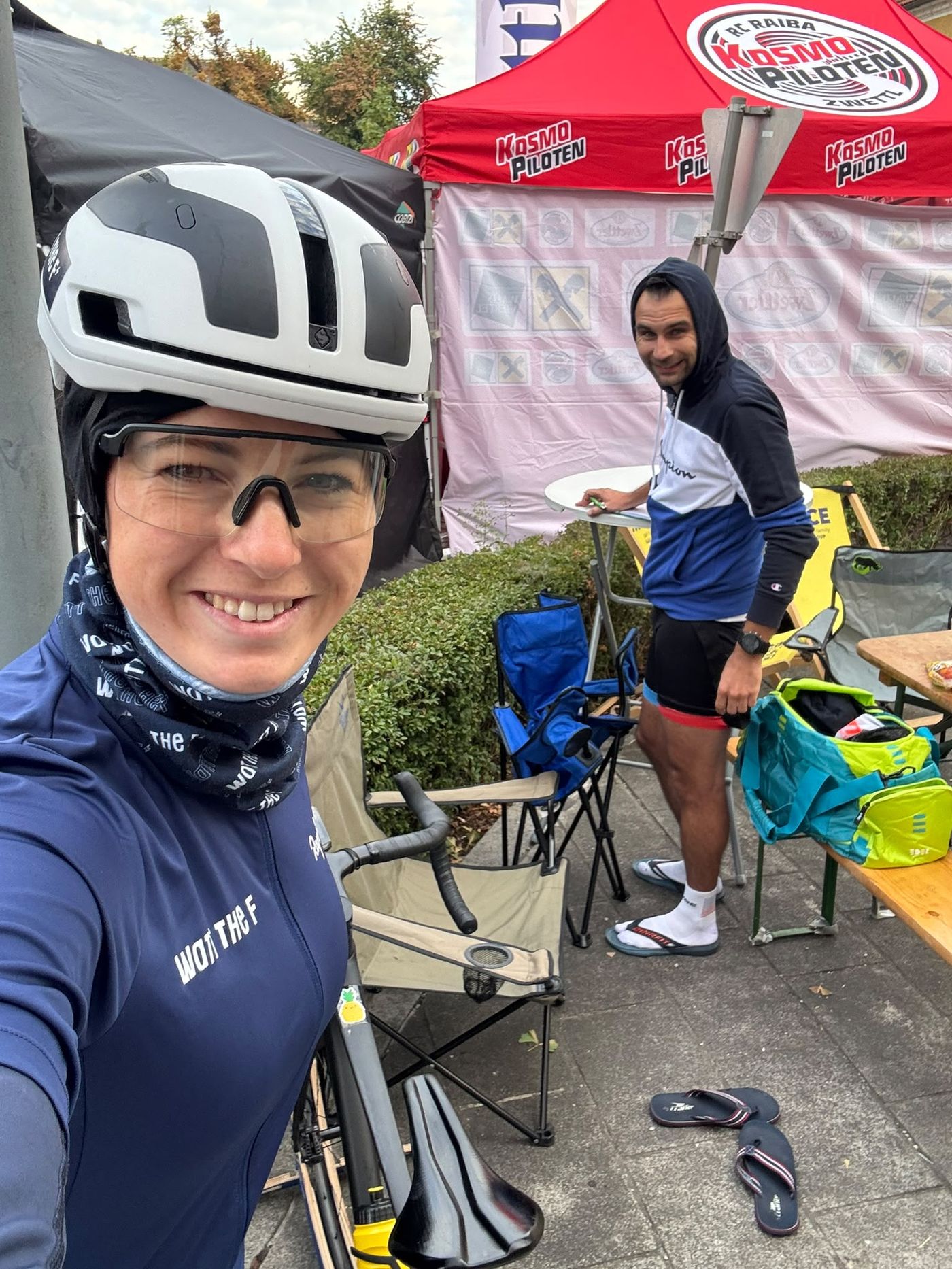 Dani mit Helm im Fahrerlager, hinter ihr unser Lager mit Campingstühlen