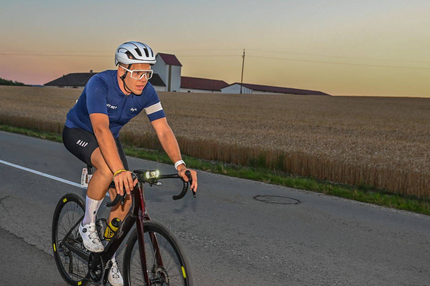 Martin im Abendlicht auf der Landstraße, dahinter ein Getreidefeld und ein Bauernhof
